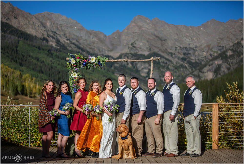 Colorful wedding party portrait with Gore Range mountain backdrop at Piney River Ranch during Autumn