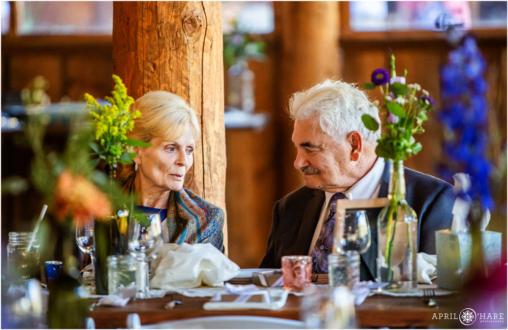 Grandparents sitting together at a pretty rustic wedding reception in Vail