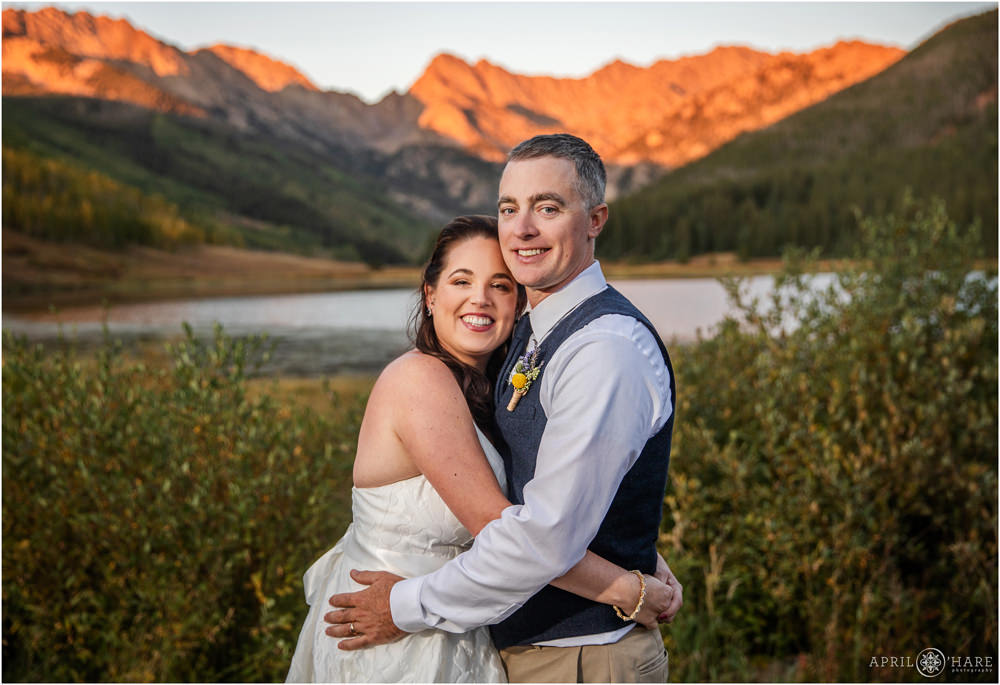 Stunning wedding portrait with the pretty orange alpenglow hitting the Gore Range at Piney River Ranch