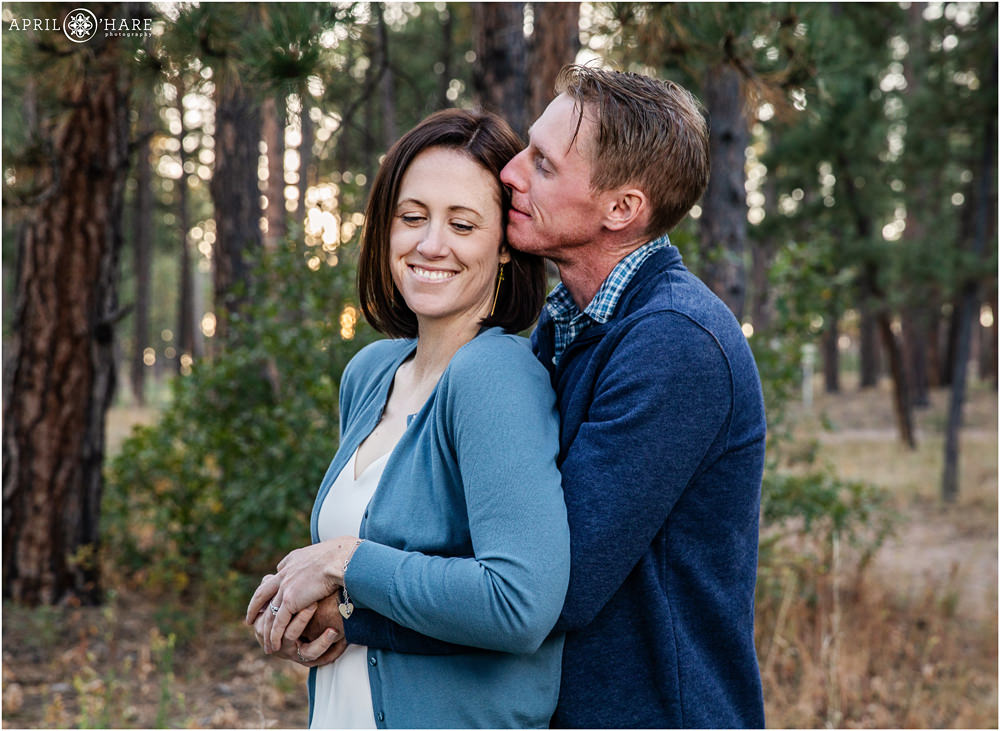 Parents of a blended family snuggle at their family photography session at Fox Run Regional Park in Colorado Springs