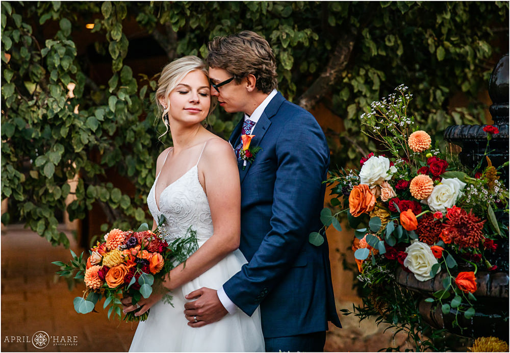 Gorgeous romantic fall wedding photo of couple with orange florals from their fall wedding at Villa Parker
