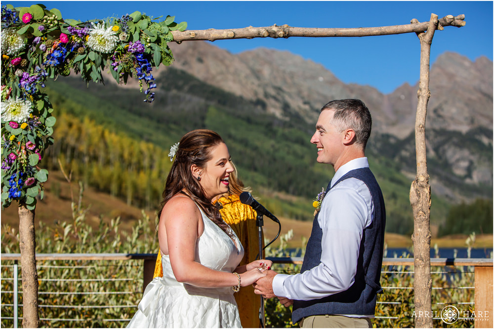 Bright and sunny wedding day ceremony with floral arch by Fancy Pansy in Vail