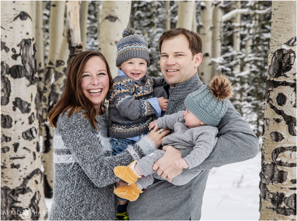 Cute candid family portrait in an aspen tree forest during winter in Colorado