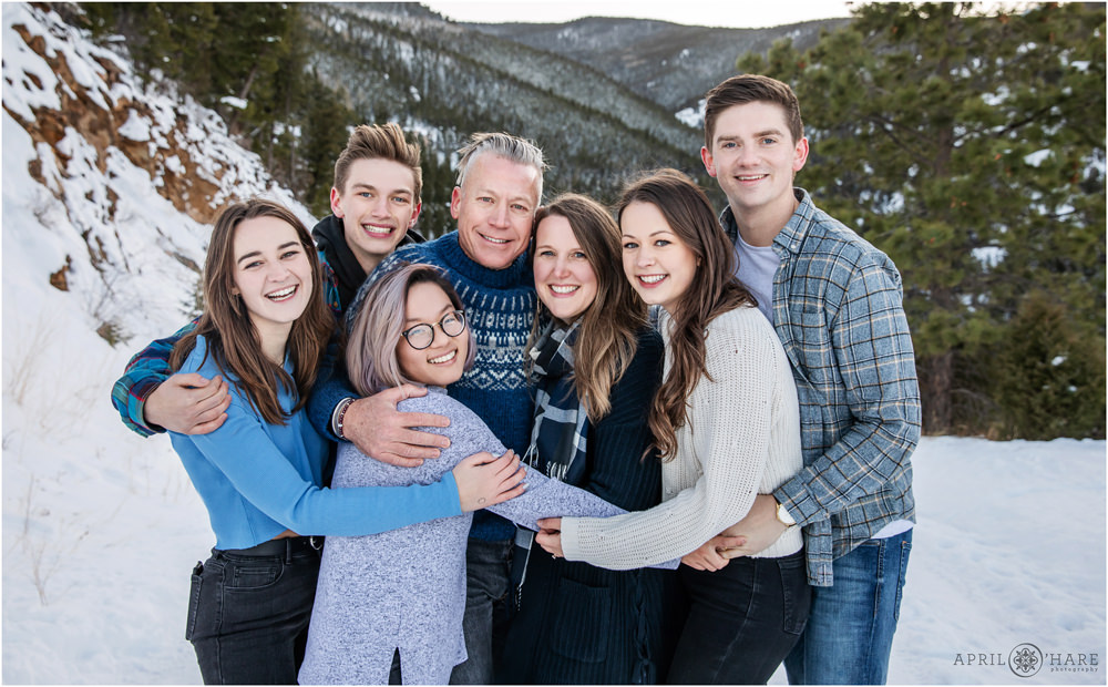 Colorado winter family picture in Evergreen with snowy mountain backdrop