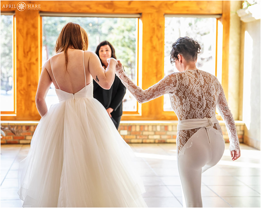 Natural light indoor wedding photo of two brides at their winter wedding at Della Terra
