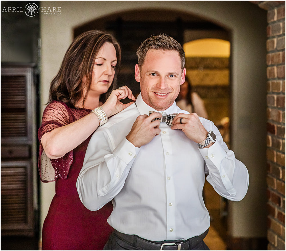 Bride's brother puts on her bow tie with help from Mom