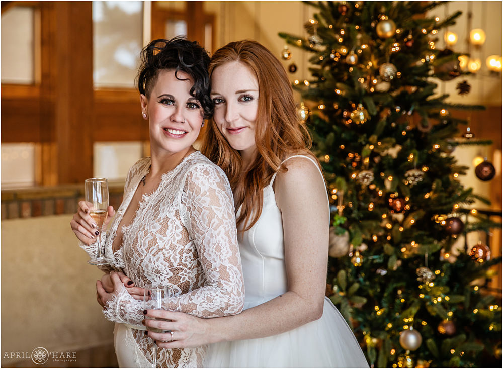 Stunning brides pose for a classic wedding portrait at their Christmas season wedding at Della Terra in Estes Park