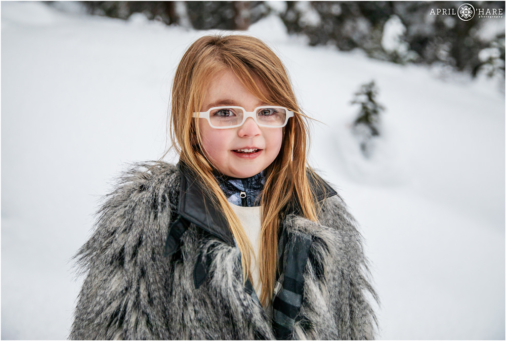 Cute little girl snowy portrait at Christmas family portrait in the woods of Colorado