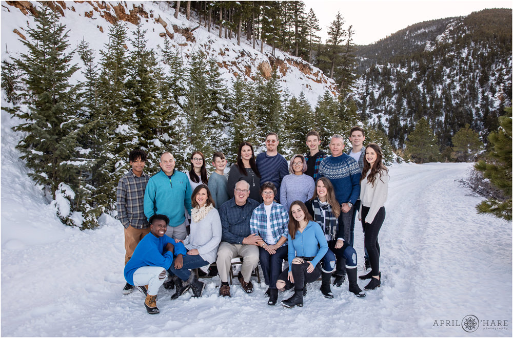 Gorgeous winter family photo in the mountains with evergreens and snow in Colorado