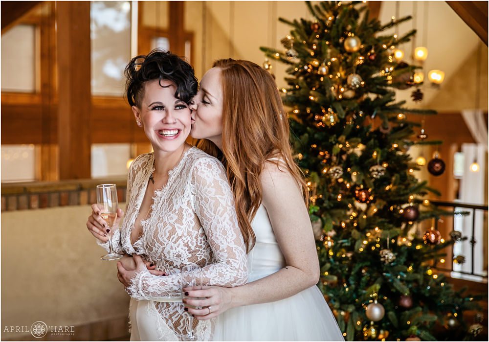 Romantic same sex wedding during Christmas season with lesbian brides snuggling at Della Terra