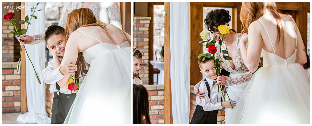 Children give roses to the brides at their same sex Christmas Wedding at Della Terra in Estes Park