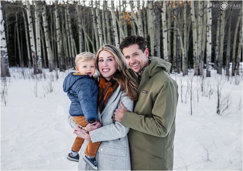 Pretty snowy Colorado family photos with aspen tree grove backdrop in Evergreen