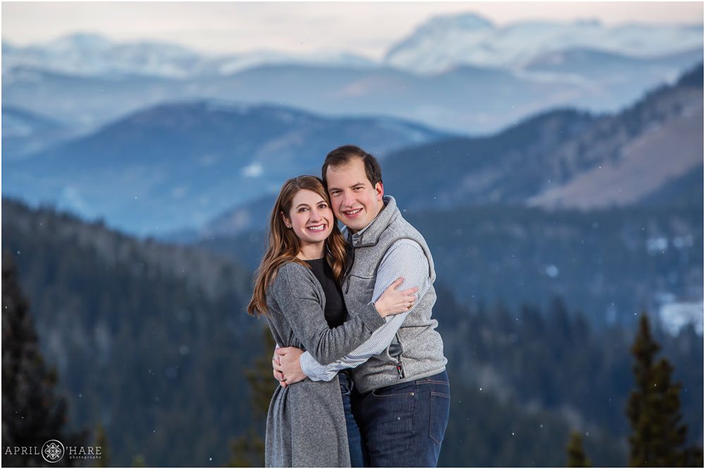 Classic family portrait for a young couple with blue mountain backdrop