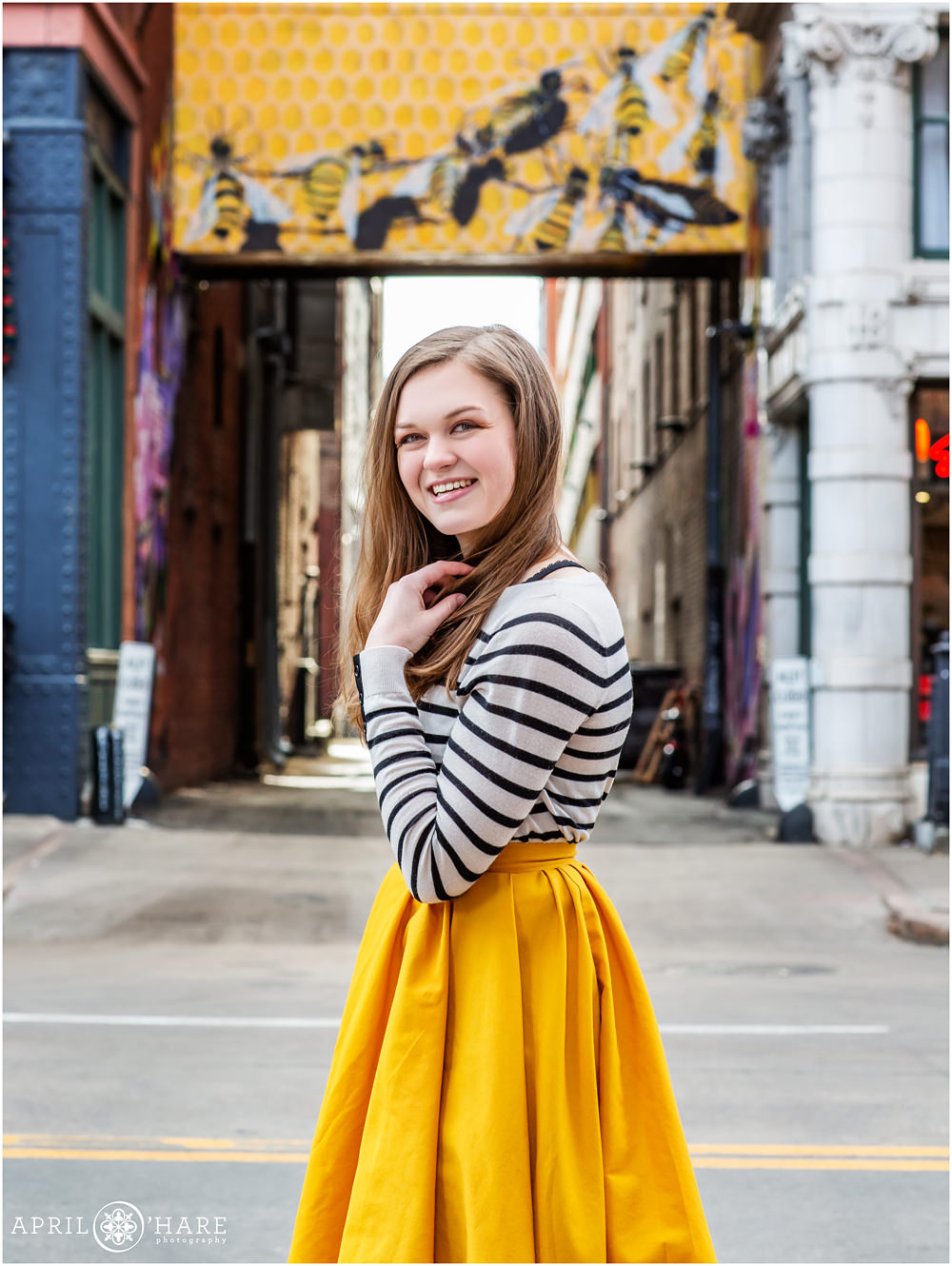 Cool downtown Denver senior photos of a girl in a pretty yellow skirt near Oxford Hotel
