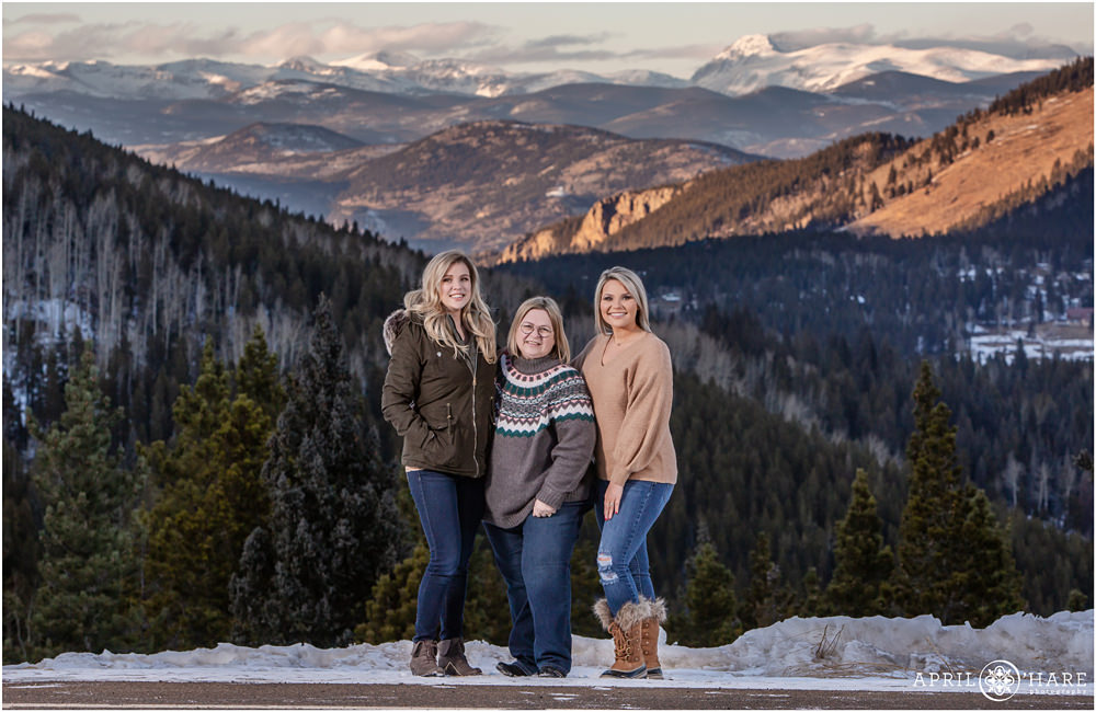A mom with her two adult daughters get a winter family picture created on Squaw Pass Road