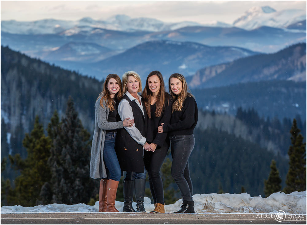 A mother and her daughters pose for a gorgeous family picture in the winter mountains of CO