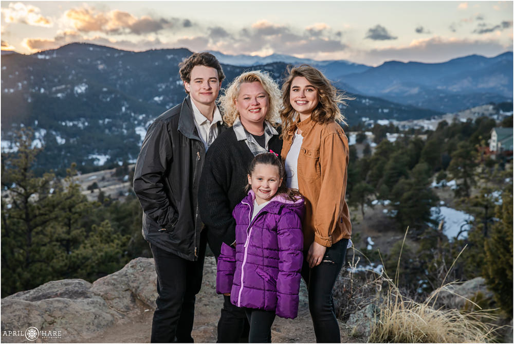 A family of four pose for a professional family portrait at sunset during winter at Mount Falcon