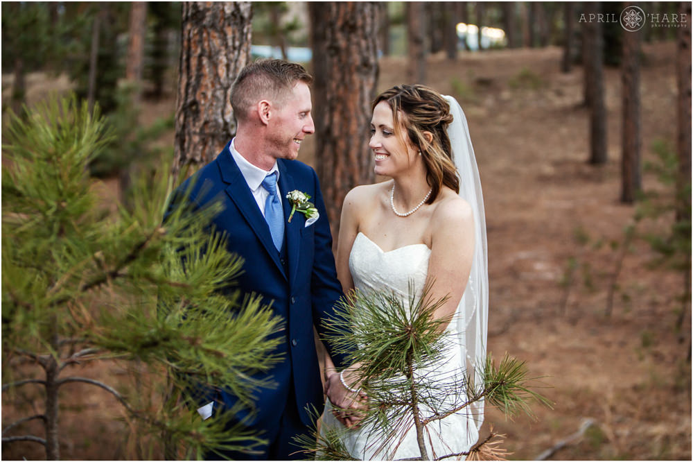 Couple laughs with each other in the woods during their wedding picture time at Black Forest in Colorado Springs