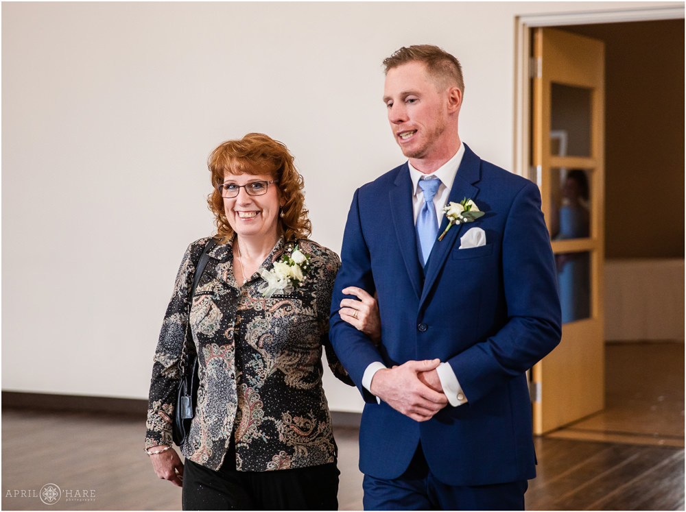 Groom walks down aisle with his mom at Indoor ceremony at Wedgewood Weddings Black Forest