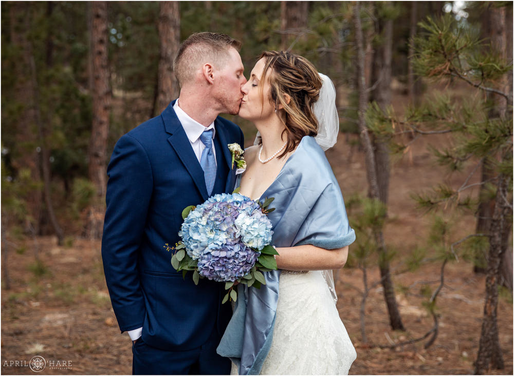 Couple kissing in the woods at their wedding