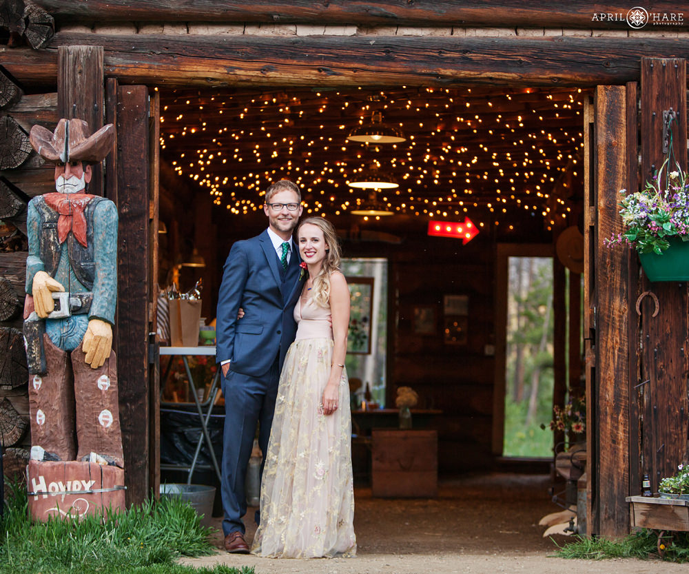barn wedding in colorado with couple posing with barn