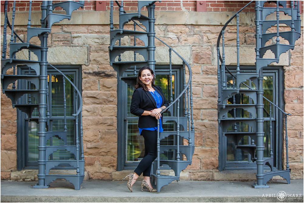 Woman poses for her business photos with the blue spiral staircases at CU Boulder