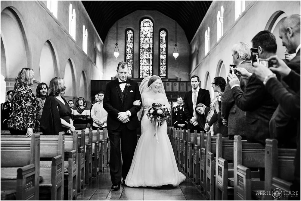 Bride walks down the aisle with her dad in at Shove Memorial Chapel at Colorado College