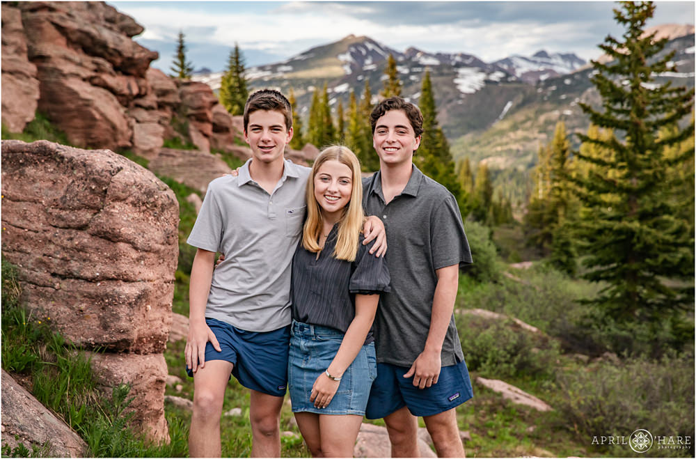 3 teenage siblings pose for a portrait on Shrine Pass near Vail Colorado