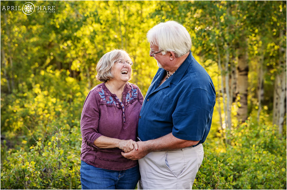 A beautiful portrait of a grandmother laughing with her husband in a pretty aspen tree forest in Granby Colorado
