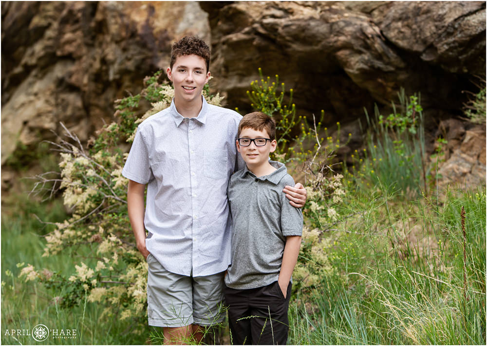 Two brothers stand side by side at their summer family session at the Clear Creek Greenway Trail in Golden