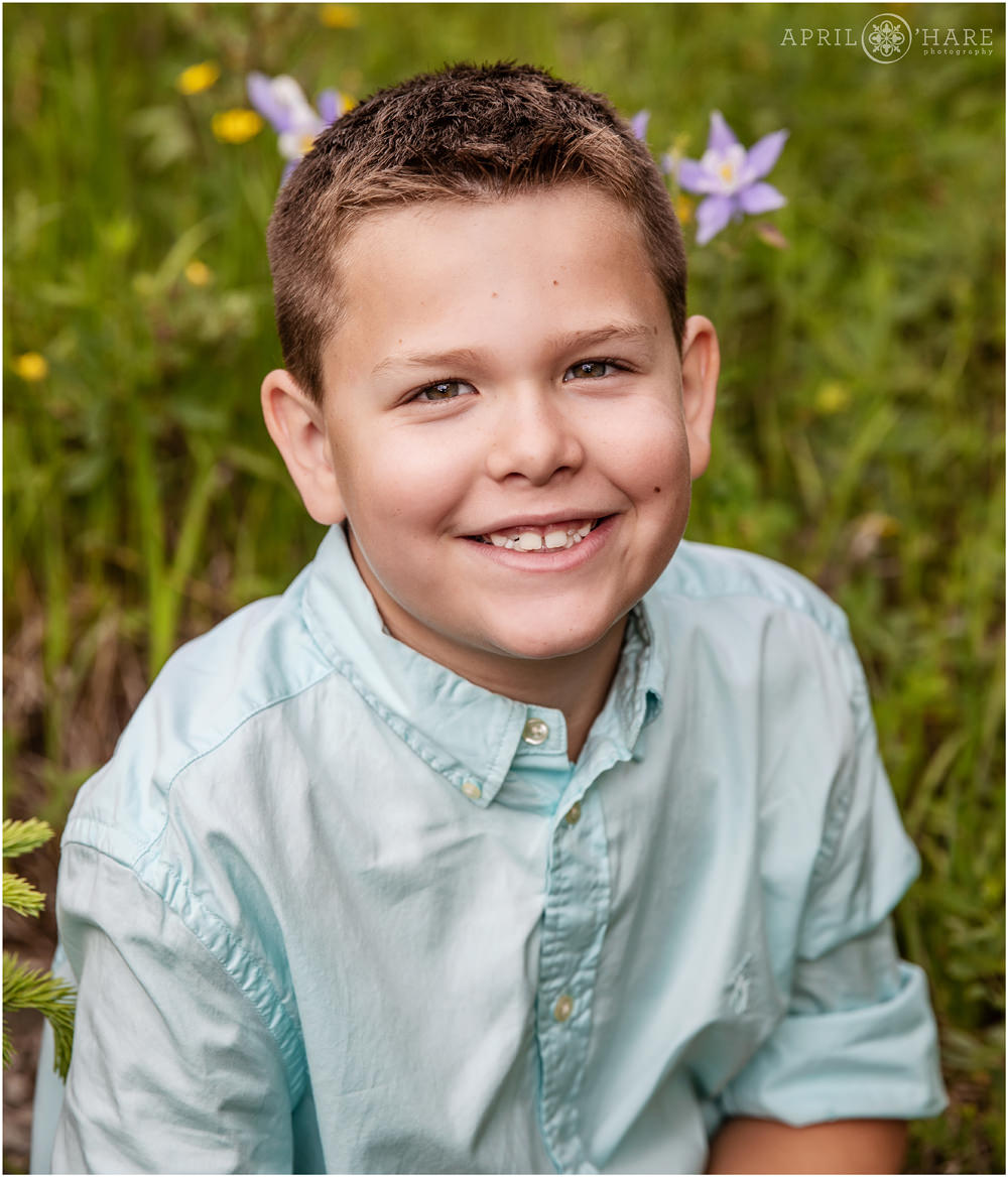 Young boy smiles naturally at his Colorado family session in Evergreen