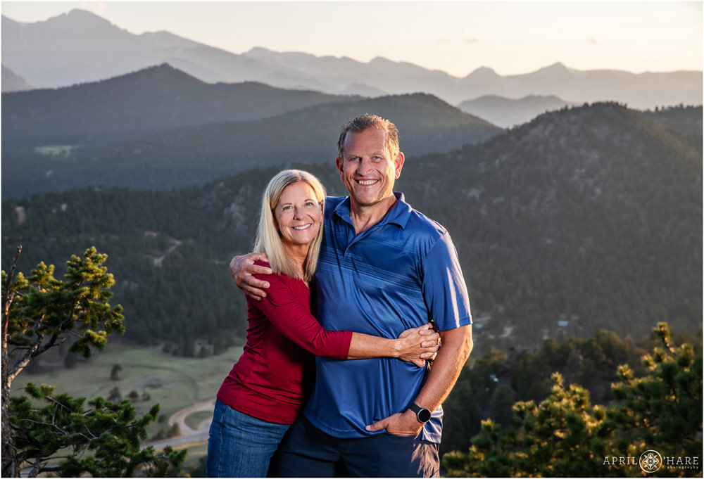 A couple pose for a casual portrait with a mountain view at their Estes Park home in Colorado
