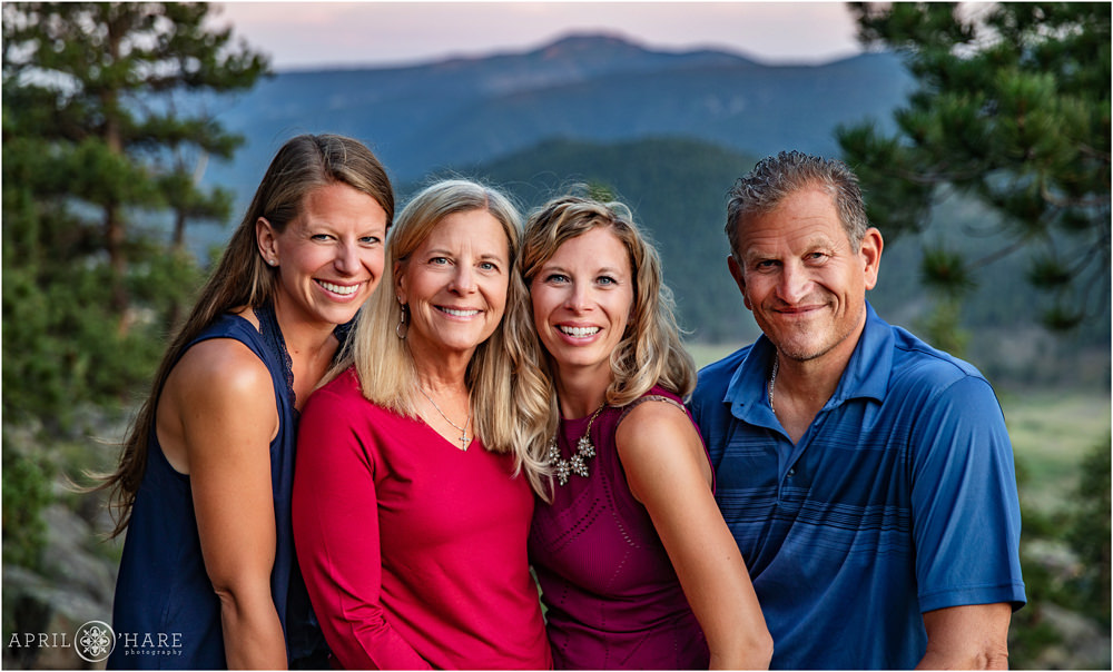 Parents with their two adult daughters pose with mountain backdrop at Sunset in Colorado