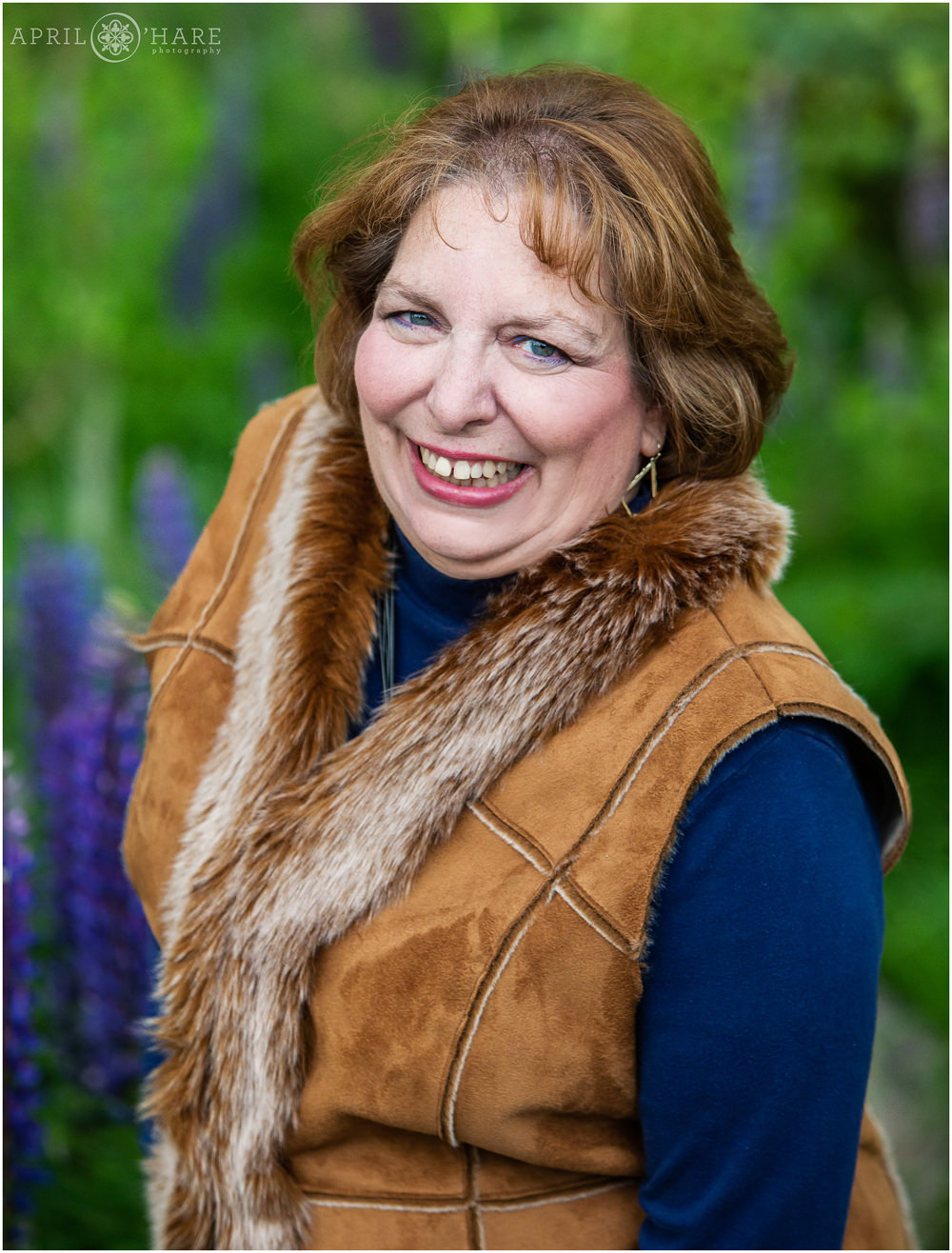 Mom gets her own headshot in a pretty mountain garden with purple wildflowers in Grand Lake