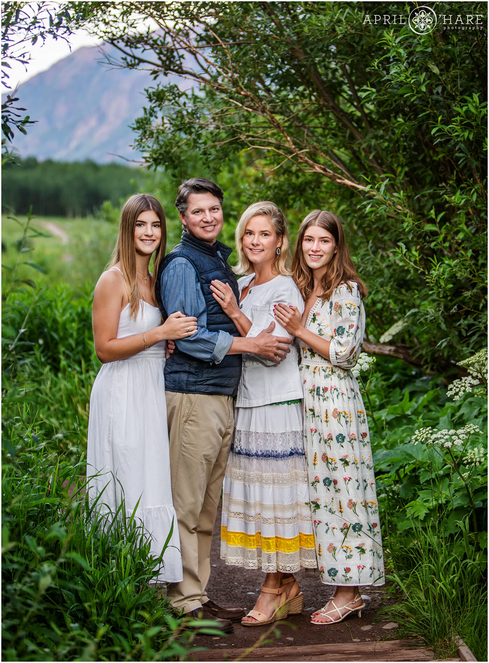 Family of four pose on a path at Maroon Bells near Snowmass Village during summer vacation in Colorado