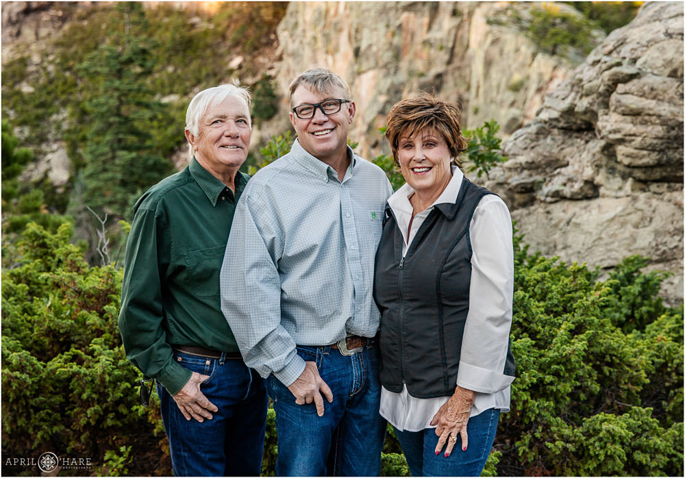 An adult son poses for a nice portrait with his parents near their hometown of La Veta Colorado