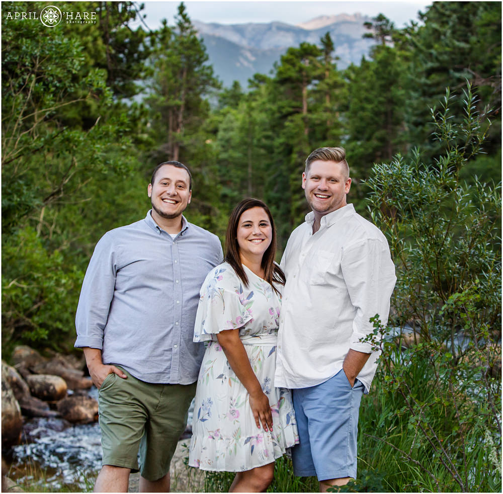 Cute summer family portrait in front of a river and mountain views in Estes Park Colorado