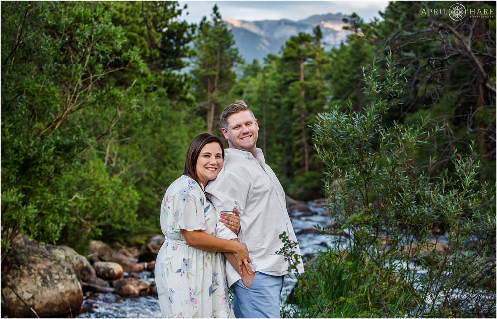 Cute photo of a couple snuggling in front of the Big Thompson River in RMNP