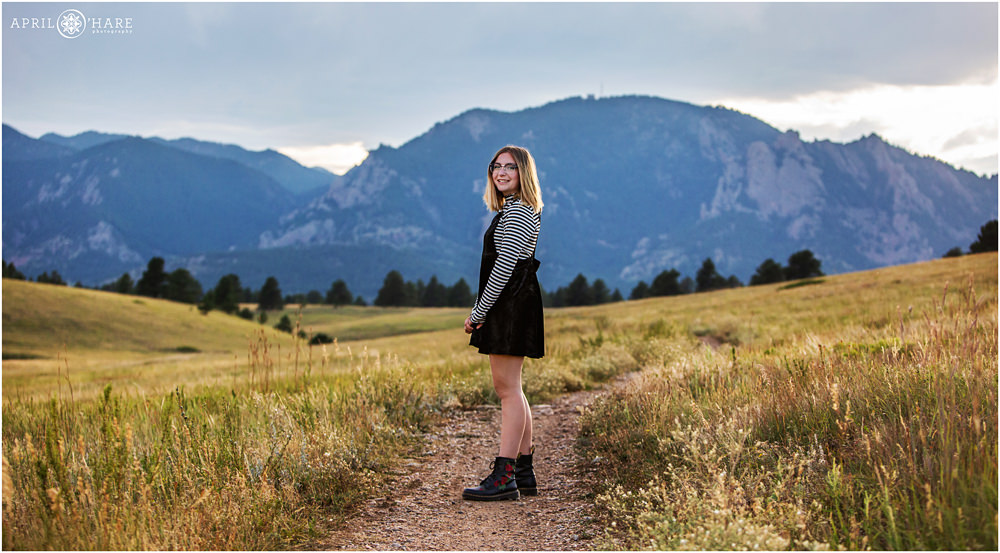 Cute photo of a senior girl posing on the path with nice mountain backdrop at Flatirons Vista Trailhead