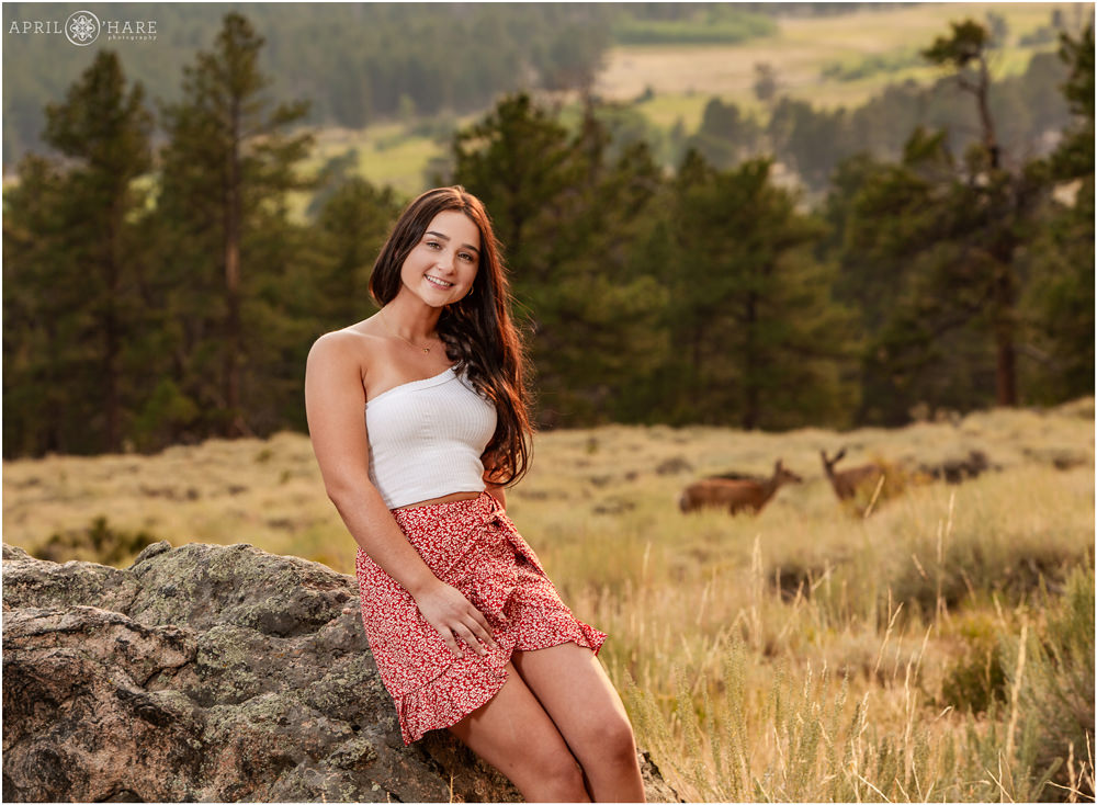 Deer in the backdrop for a senior yearbook photo at Rocky Mountain National Park in Estes Park