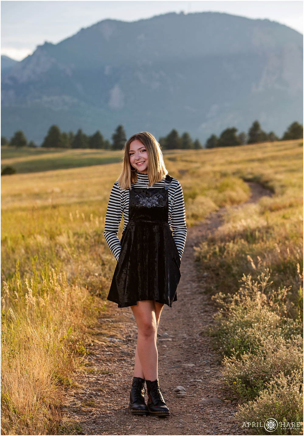Cute high school senior girl wearing B&W stripes and black jumper with combat boots at Flatirons Vista Trailhead in Boulder