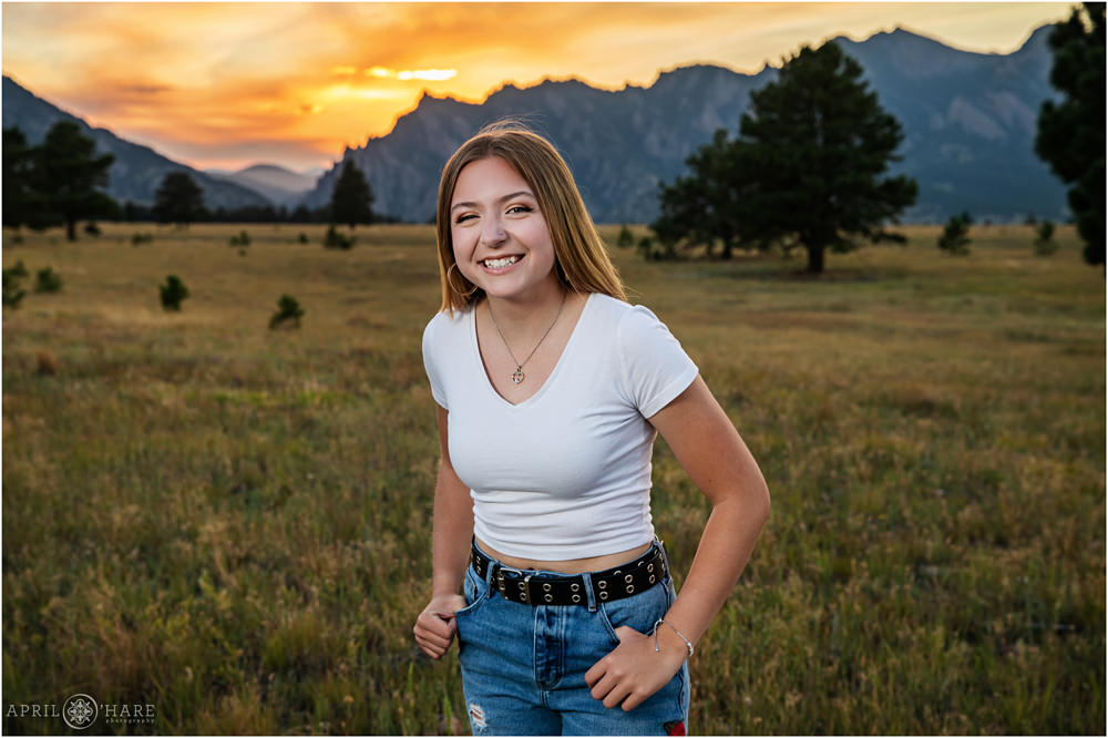 A happy high school senior girl laughs at her yearbook portrait session at Flatirons Vista in South Boulder