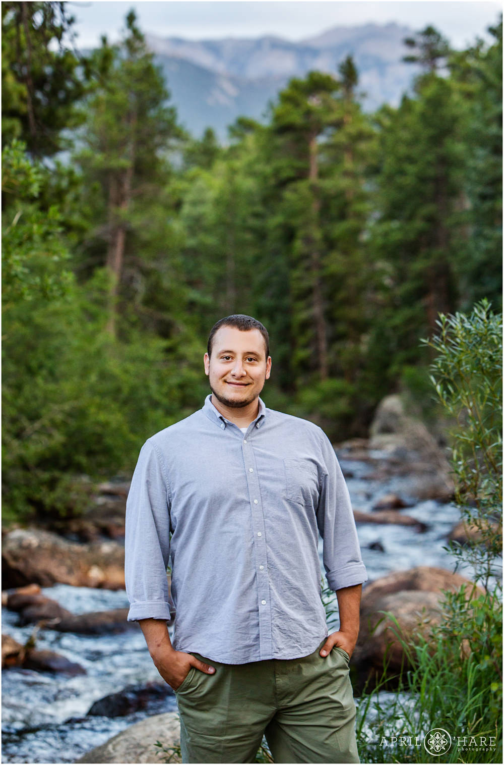 A man poses for a portrait in front of Big Thompson River in RMNP