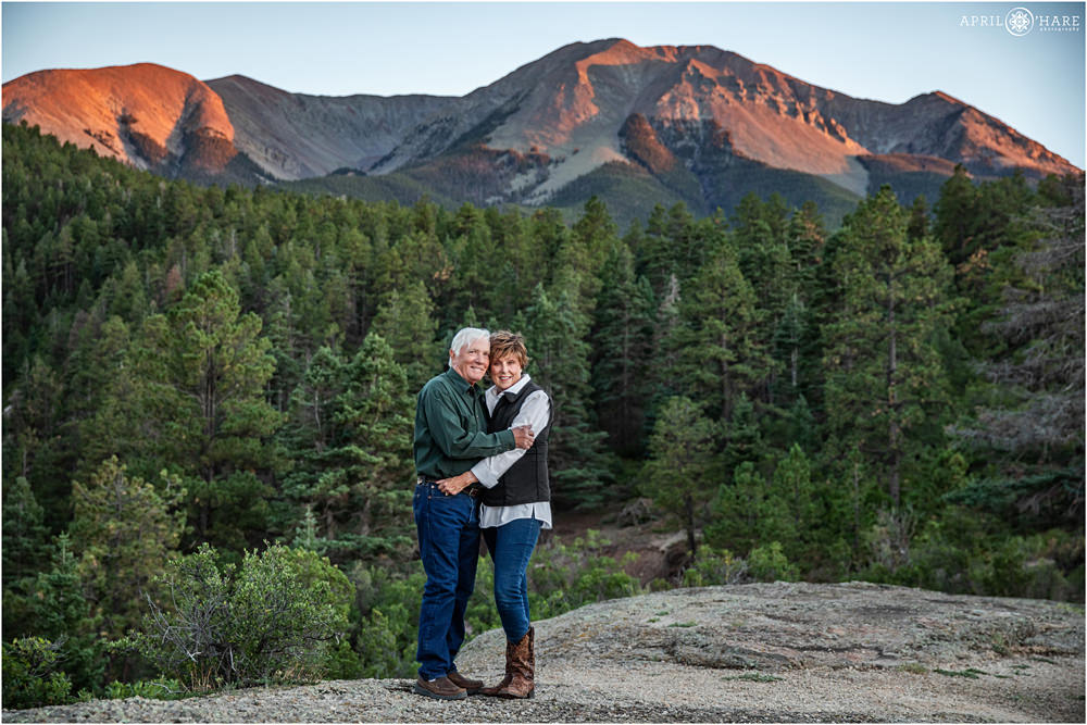 Full length photo of grandparents posing together in front of the pretty Spanish peaks at sunset in Southern Colorado