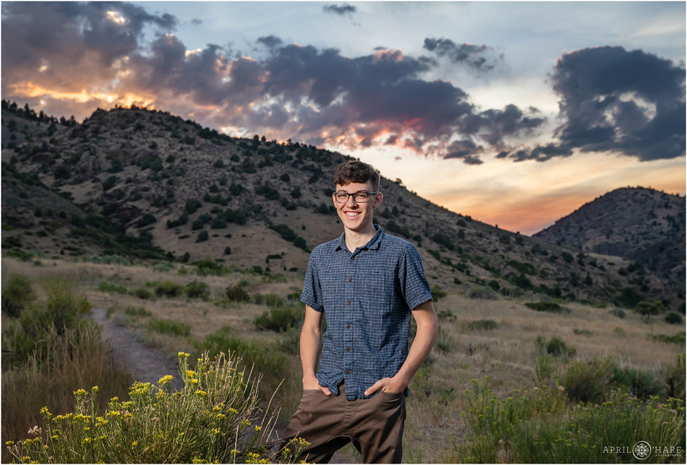 High School Senior Boy poses at sunset with the views at East Mount Falcon Trail head in Morrison Colorado