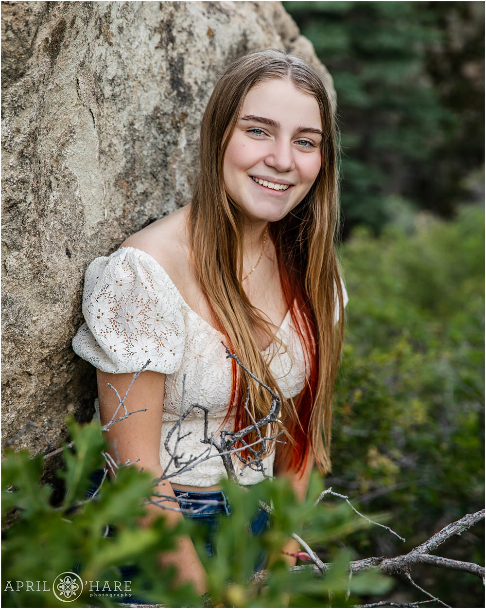 Teen girl wearing white peasant blouse poses for individual portrait at Lovers Leap in Southern Colorado