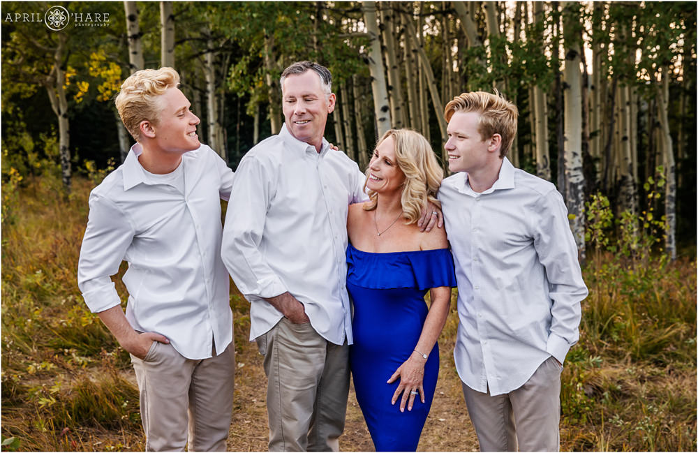 A candid family photo for a family of 4 with two teen boys in an aspen tree forest in Colorado