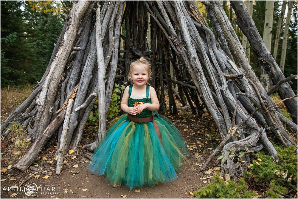 Sweet 3 year old girl wearing her cute Halloween costume in the woods of Colorado