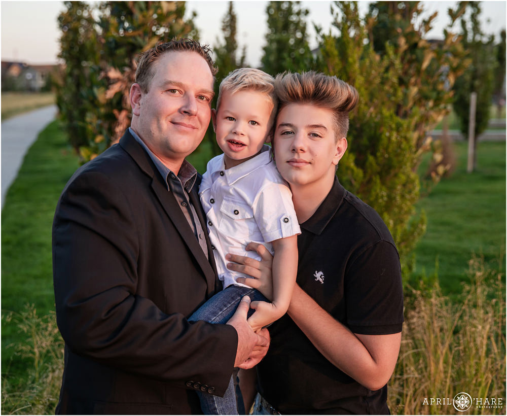 A dad with his two sons at their northeast Denver family photography session at Prairie Meadows Park