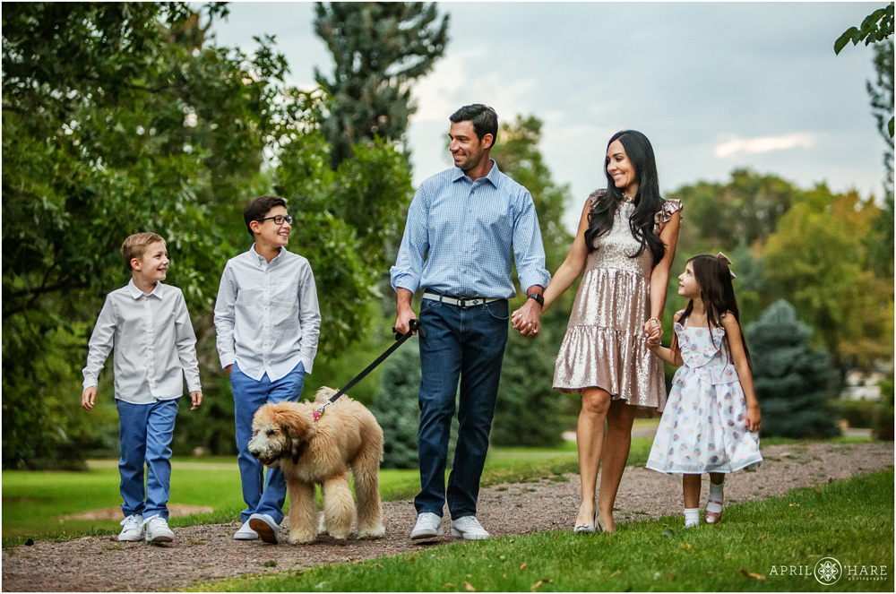 Family of 5 with a cute dog walk together at their family pictures in Littleton Colorado